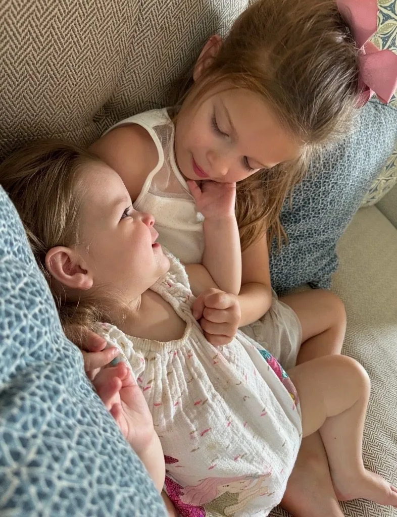 Isa cuddling with her sister on the couch