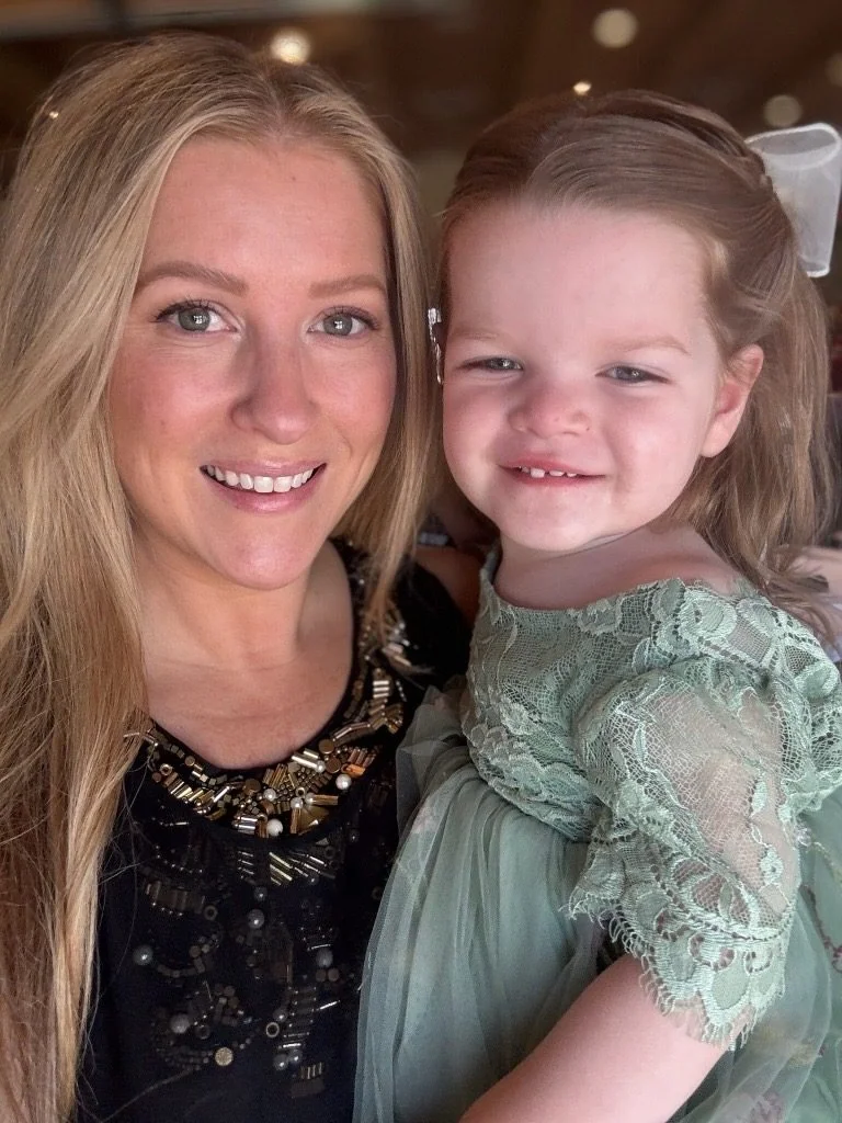 Rachel holding Isa, who is dressed up and smiling